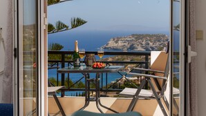 A balcony with a table set for two, featuring a bottle of wine, glasses, and a bowl of strawberries. - FnK Apartments (Malevizi)