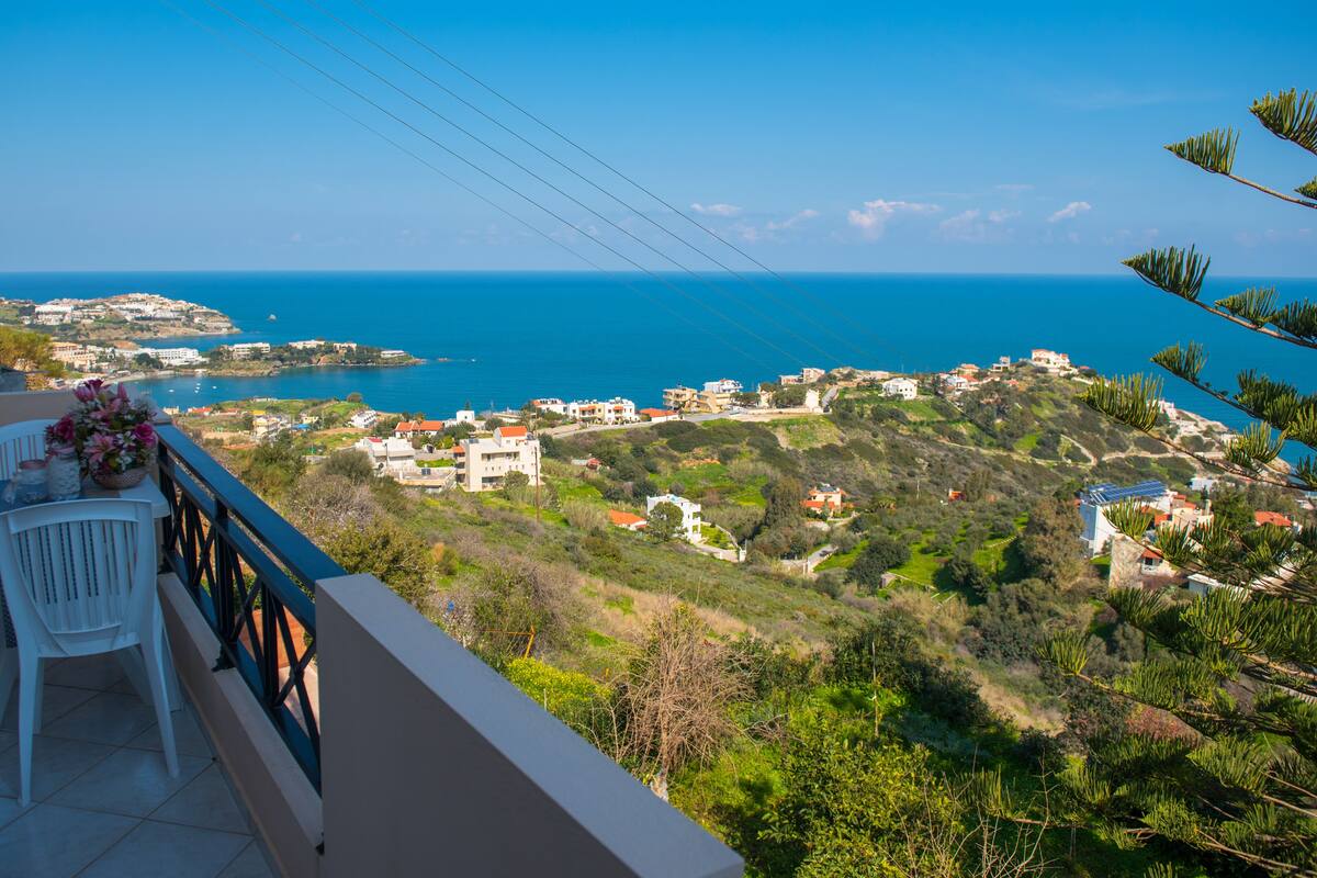 A balcony with a view of a coastal town and the sea.