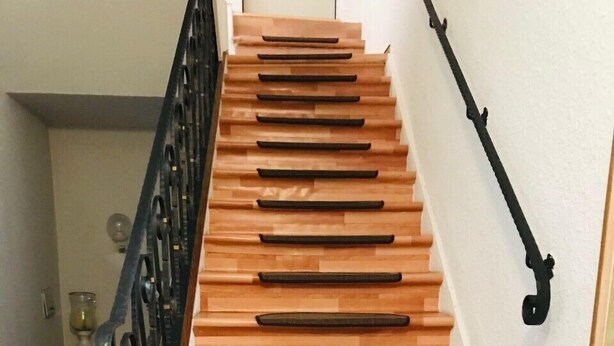 A wooden staircase with black handrails and a black banister. - Hotel restaurant germania (Bernkastel-Kues)
