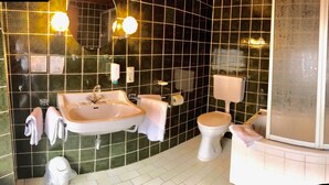 A bathroom with a sink, toilet, and shower area. - Hotel restaurant germania (Bernkastel-Kues)