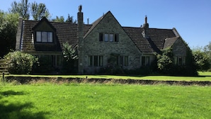 A stone house with a large lawn in front. - Oxbridge Farm (Bridport)