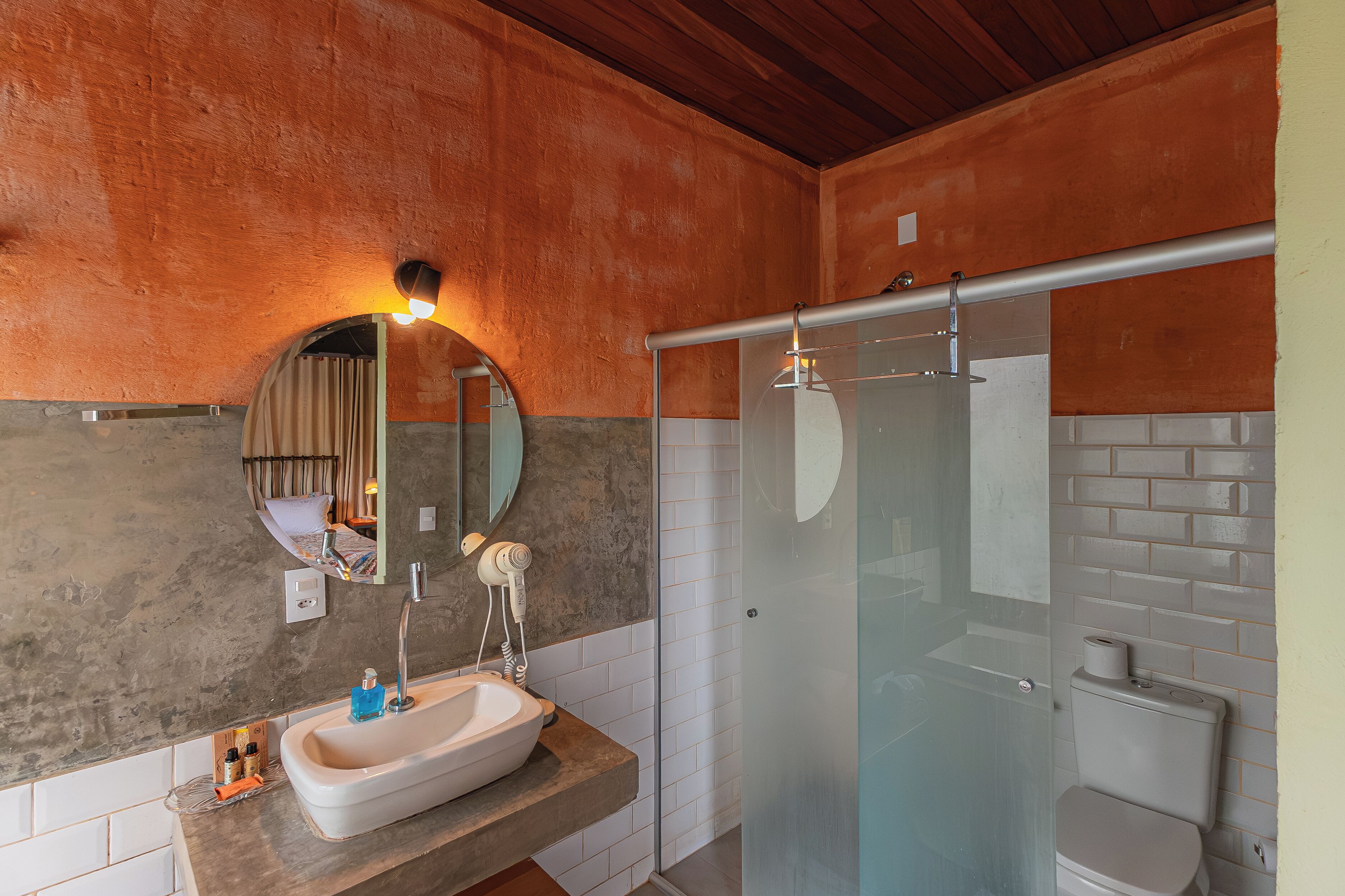 Un baño con lavamanos, espejo y ducha.