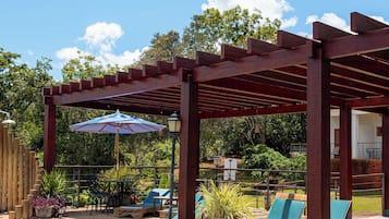 Una piscina al aire libre, sombrillas, sillones reclinables de piscina
