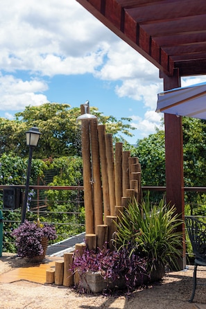 A wooden structure with a metal roof, surrounded by potted plants and a metal fence. - Serra do Juá Pousada de Campo (Pirenópolis)