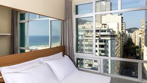 Una habitación de hotel con un ventanal que ofrece vistas a la ciudad y al mar.