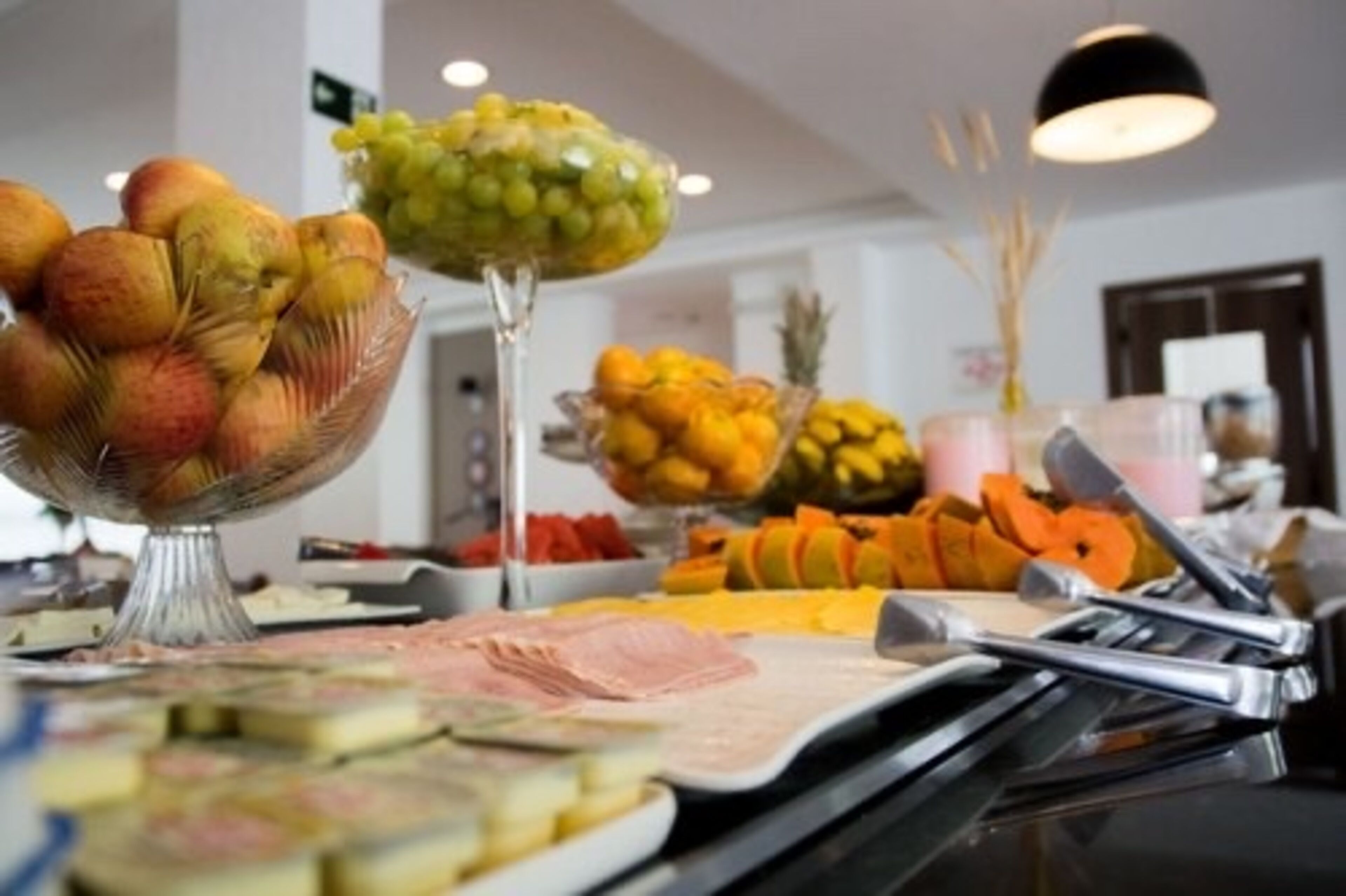 Een buffet met verschillende soorten fruit en een keuze uit vleeswaren.
