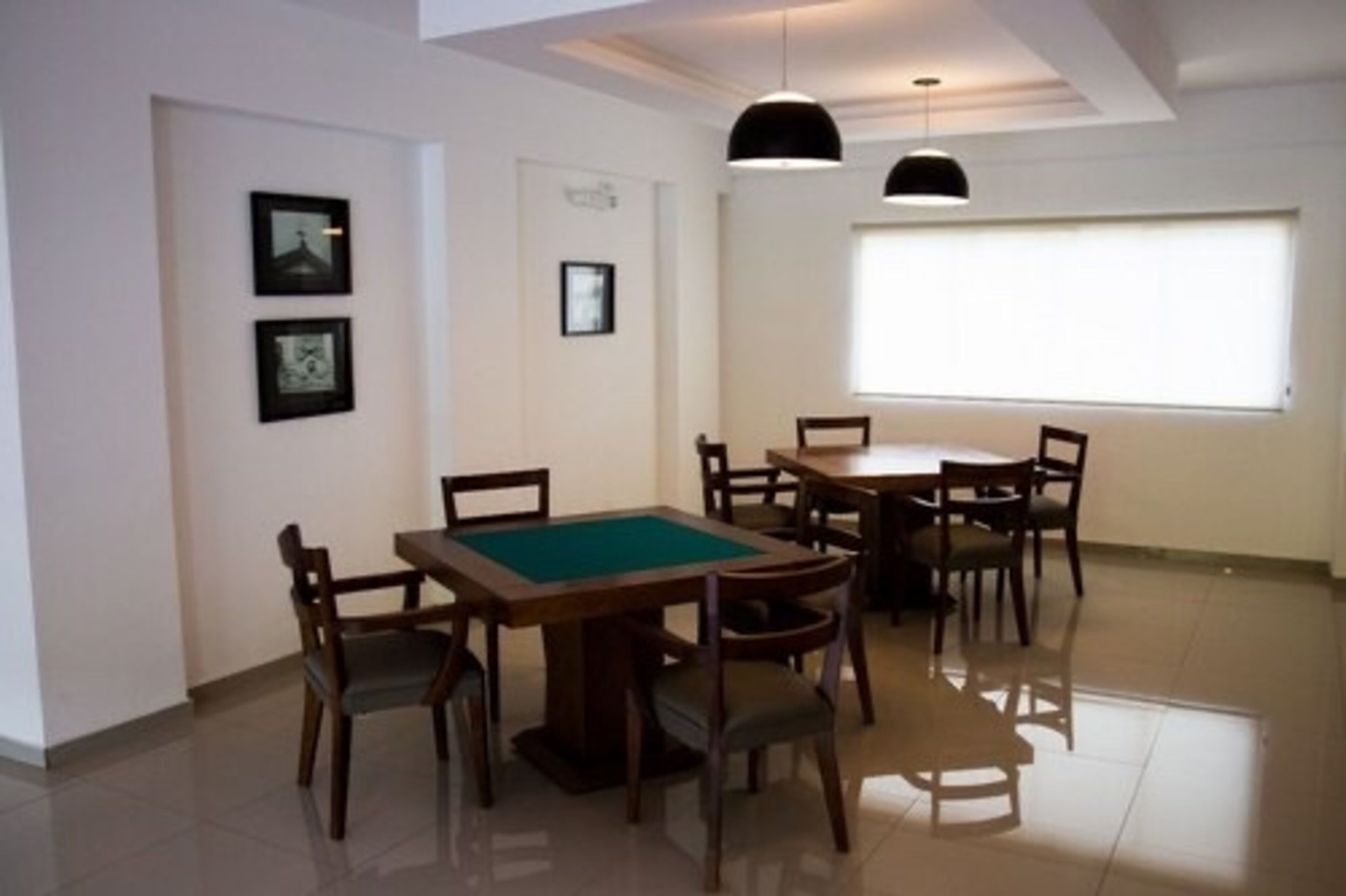 Un comedor con mesa de billar, varias sillas e iluminación colgante.
