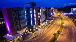A modern hotel with a glass facade and a sign reading "HOTEL PORTO REAL".