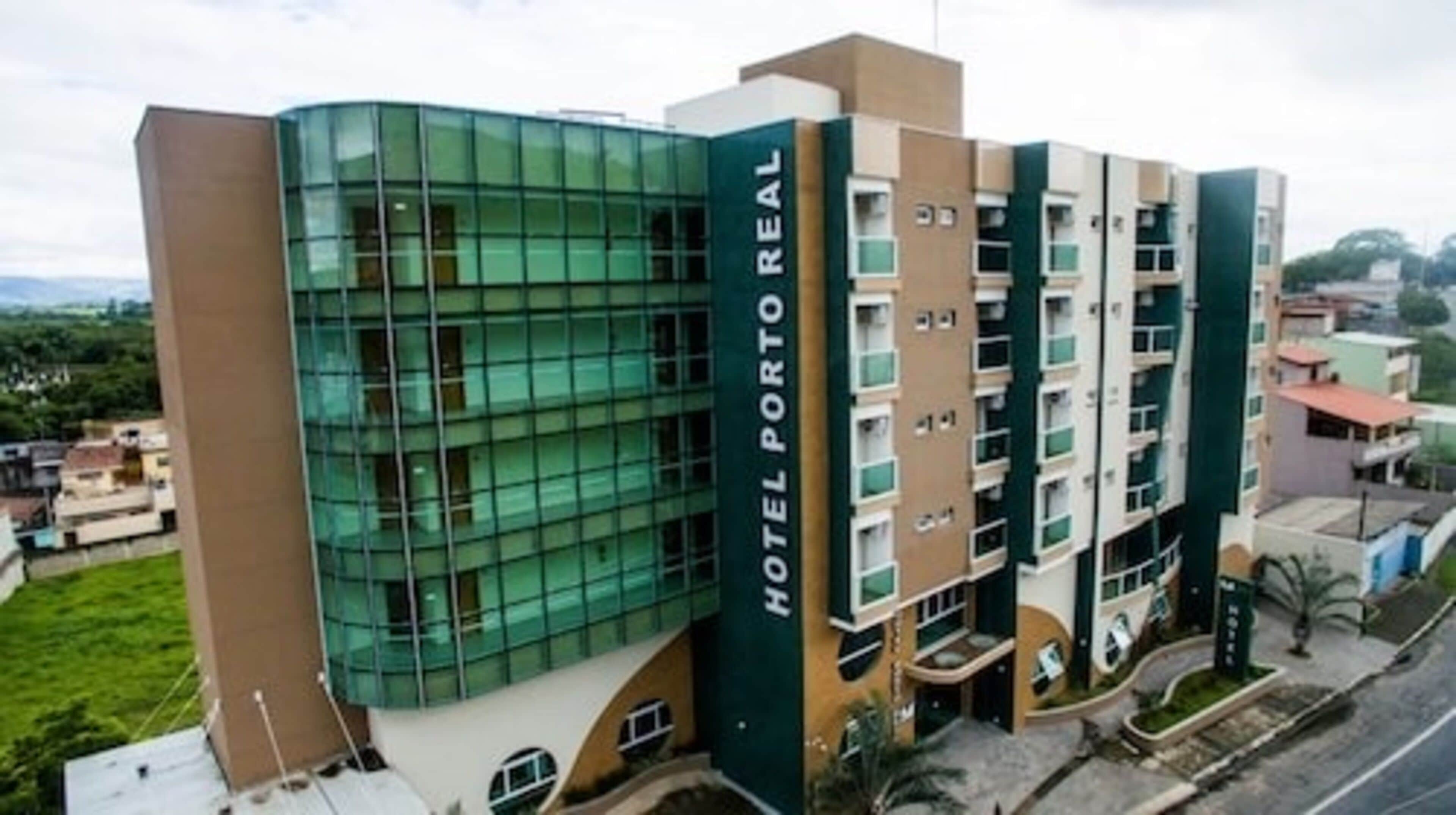 A multi-story hotel with a modern glass facade and a sign reading "HOTEL PORTO REAL".