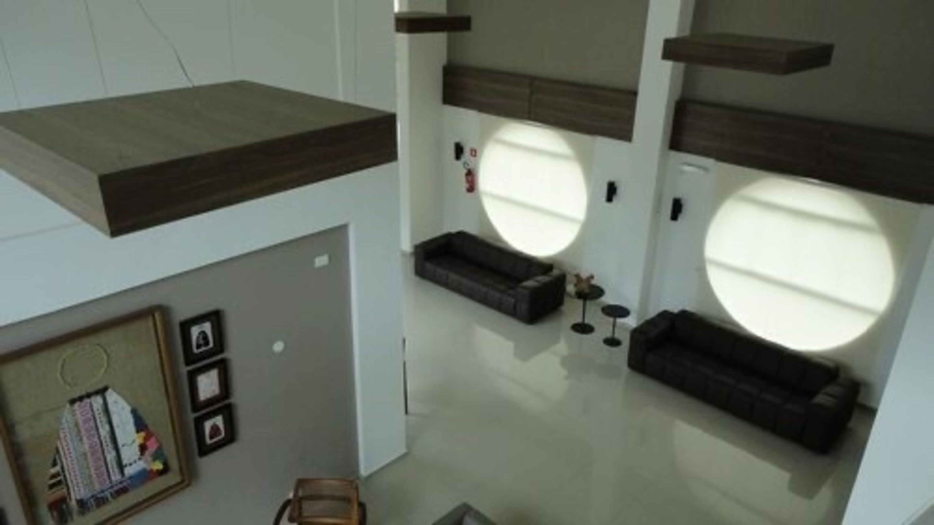 Een modern interieur met een centraal zitelement, inbouwkasten en grote ramen.