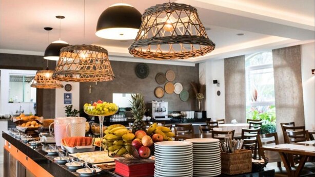 A buffet area with wicker pendant lights, fruit display, and dining tables.