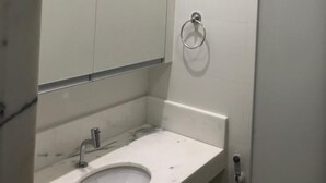 Ein Badezimmer mit Marmorwaschbecken, Spiegel und Handtuchhalter.
