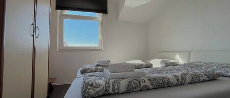 Une chambre à coucher avec un lit, une fenêtre et une armoire.