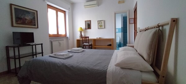 A bedroom with a bed, a desk, a chair, a television, and a window. - B&B Vanvitelli (Caserta)