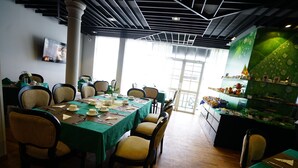 A dining area with a long table set for six, surrounded by chairs with cushioned seats. - Horton Towers & Cottages (Nuwara Eliya)