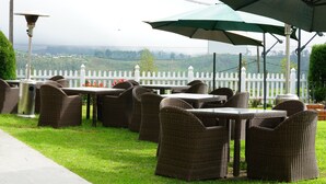 Outdoor patio furniture with a view of a white picket fence and greenery. - Horton Towers & Cottages (Nuwara Eliya)