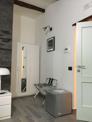 A modern room with a wardrobe, a chair, a desk, and a door. - Franz Guest House (Naples)