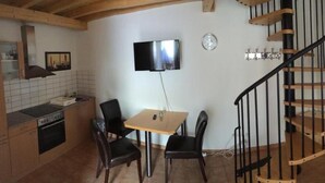 A compact living space with a kitchen, dining area, and a staircase. - Hotel Stadt Coblenz (Fachbach)