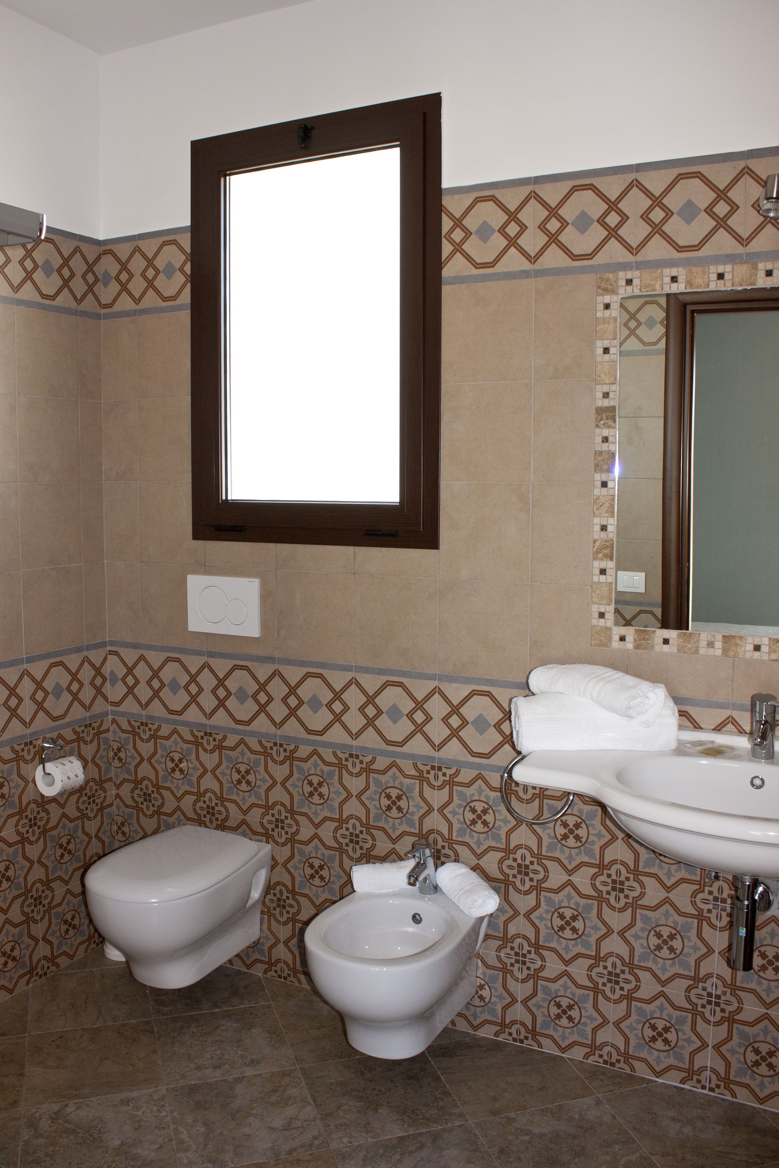 A bathroom with a toilet, bidet, and sink.