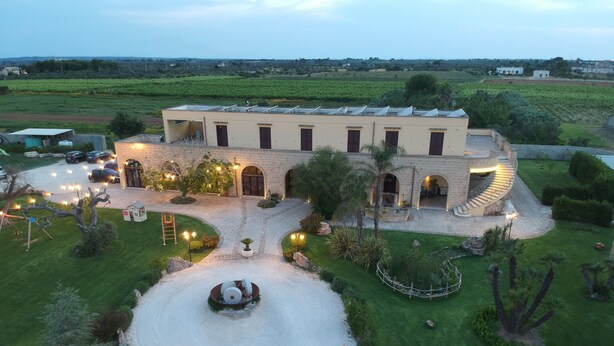 A large building with multiple arched doorways and a central courtyard. - Agriturismo Paradiso (Parabita)