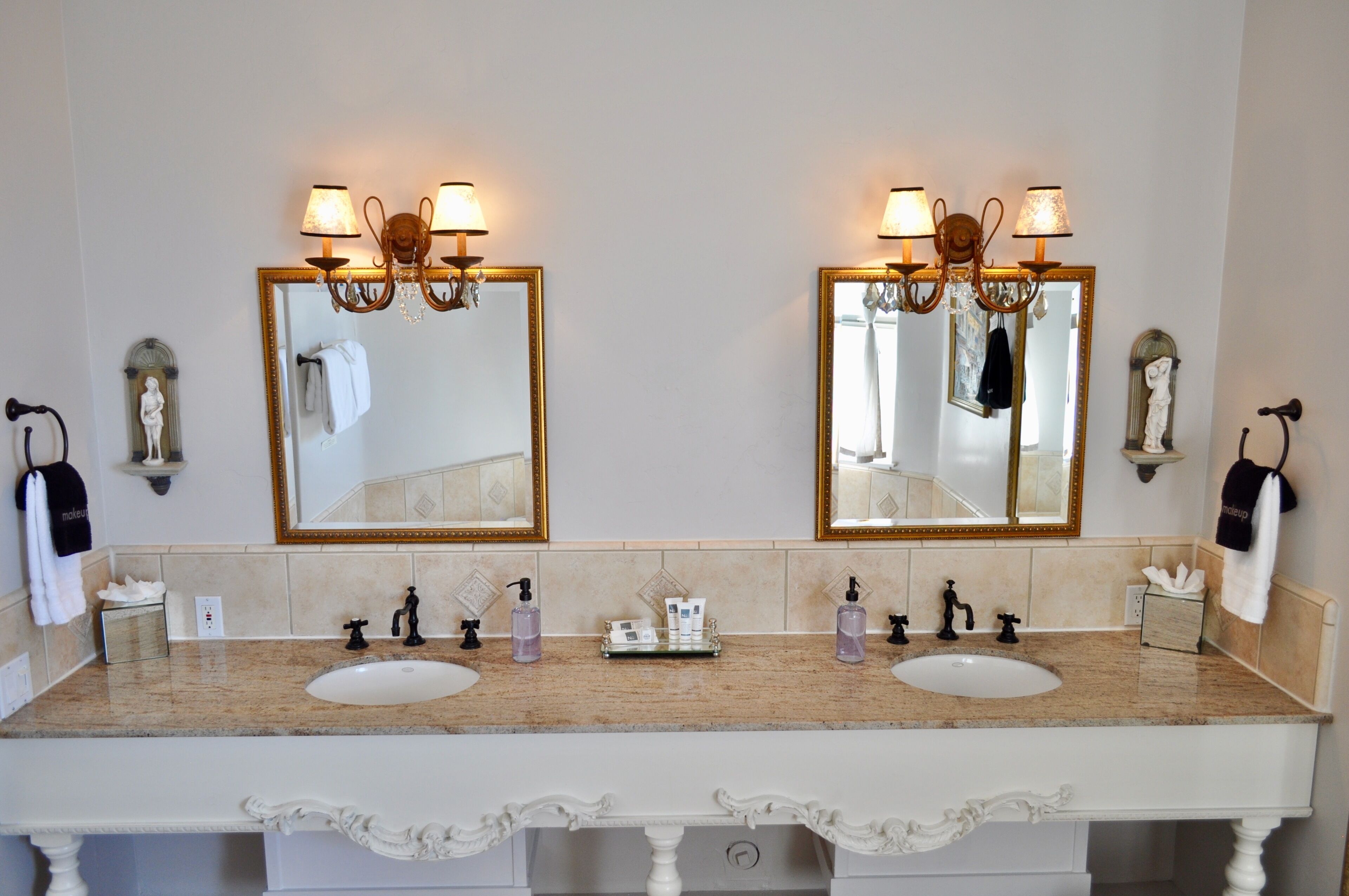 A bathroom with two sinks, a vanity, and a large mirror.