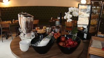 Montaje de un bufé de desayuno con diversos alimentos y bebidas.