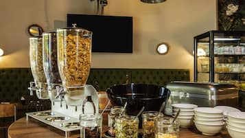 Una mesa de buffet con varios recipientes y fuentes de comida.