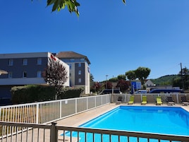 Una piscina al aire libre de temporada, sillones reclinables de piscina