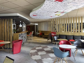 A modern interior with a curved ceiling, wooden paneling, and a mix of red and grey seating. - ibis Cahors (Cahors)