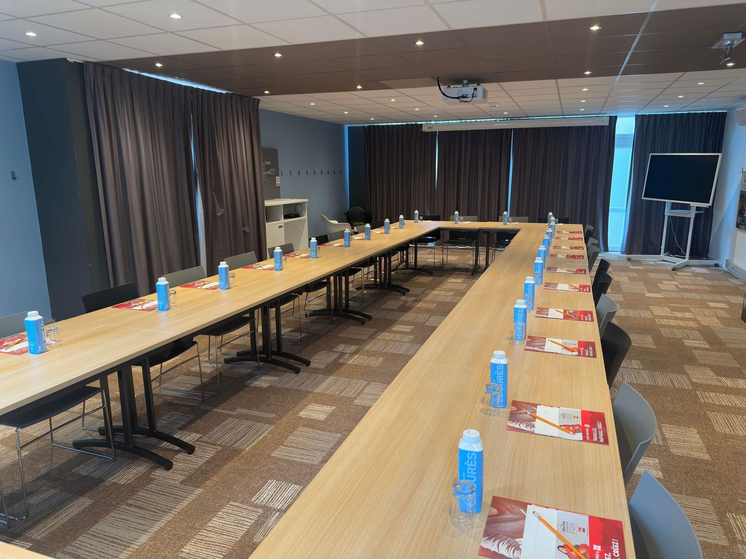 A conference room with a long table, chairs, and water bottles.