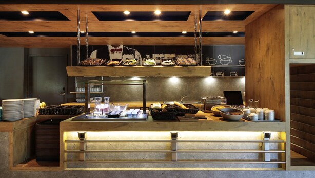 A breakfast bar with a variety of food items and beverages, a coffee machine, and a toaster. - ibis budget Cahors (Cahors)