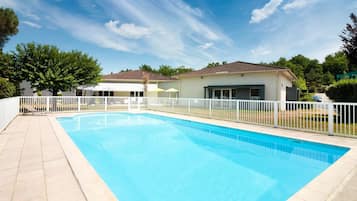 Een seizoensgebonden buitenzwembad en parasols bij het zwembad