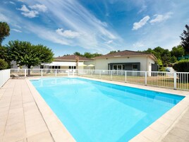 Una piscina al aire libre de temporada, sombrillas