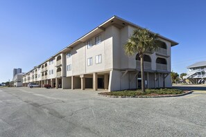 A multi-story hotel with a flat facade, balconies, and a parking area. - Las Palmas 224 2 Bedroom Condo by RedAwning (Gulf Shores)