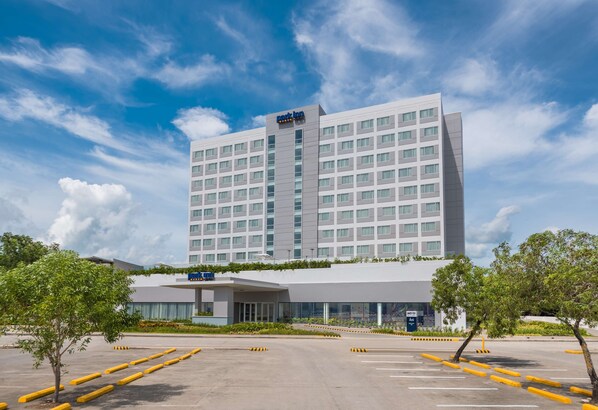 Un hotel moderno con techo plano y un amplio estacionamiento.