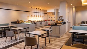 A modern restaurant with a central island, multiple seating areas, and pendant lighting.