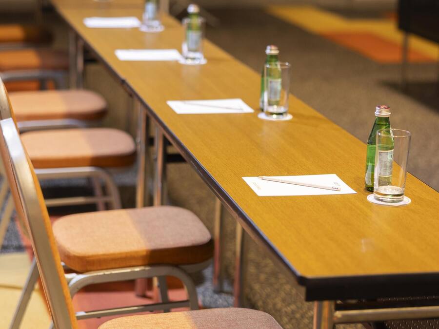A conference room with a long table, chairs, water bottles, and name cards.