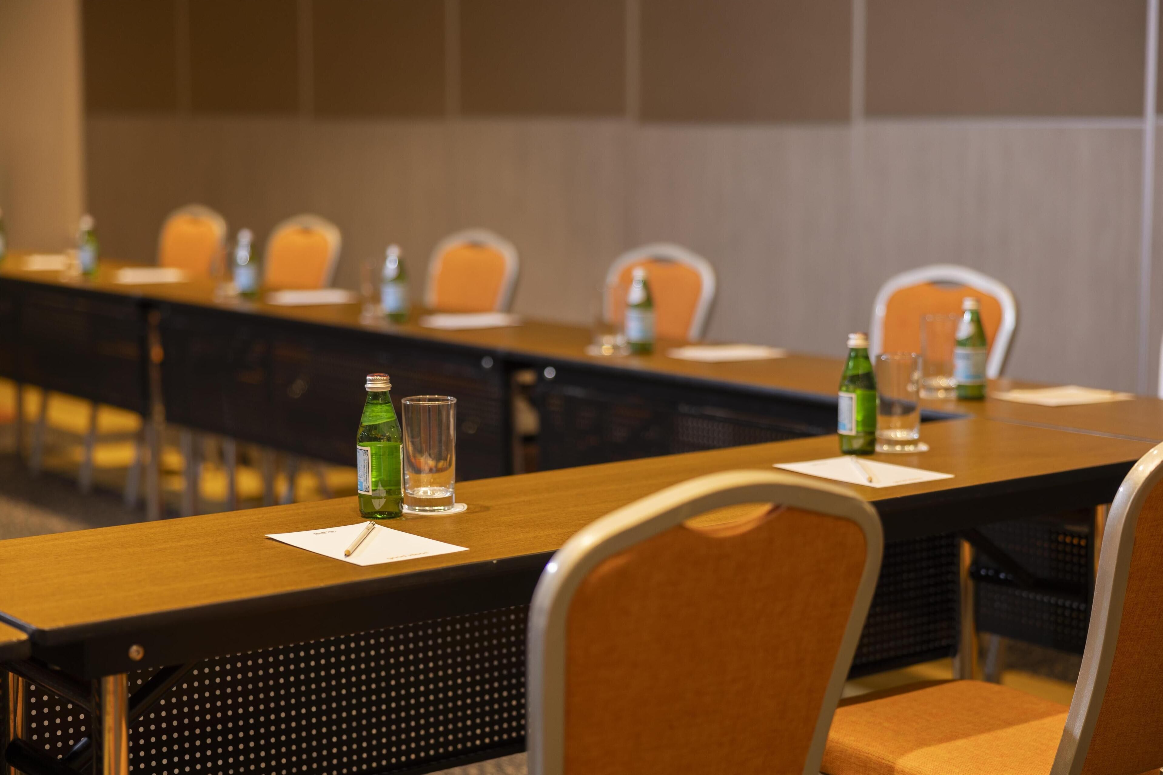 A conference room with a long table, chairs, and water bottles.