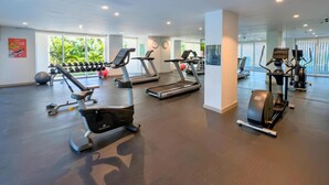 A gym with treadmills, elliptical machines, and free weights.