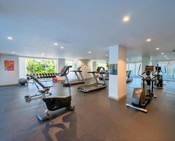 A gym with treadmills, elliptical machines, and free weights.