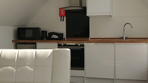 A modern kitchen with a white countertop, a built-in oven, and a white cabinet.