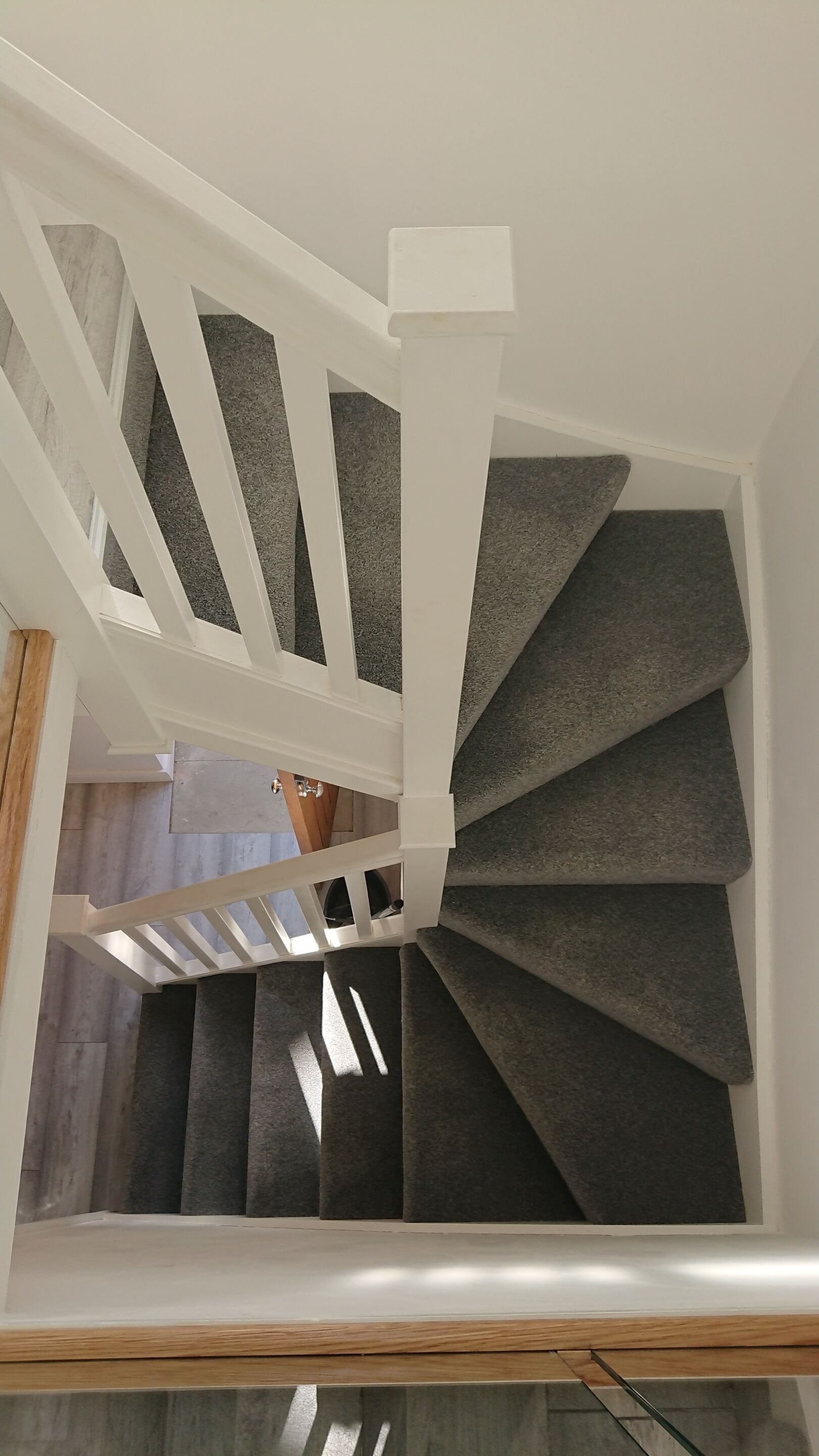 A staircase with a white railing and dark steps.