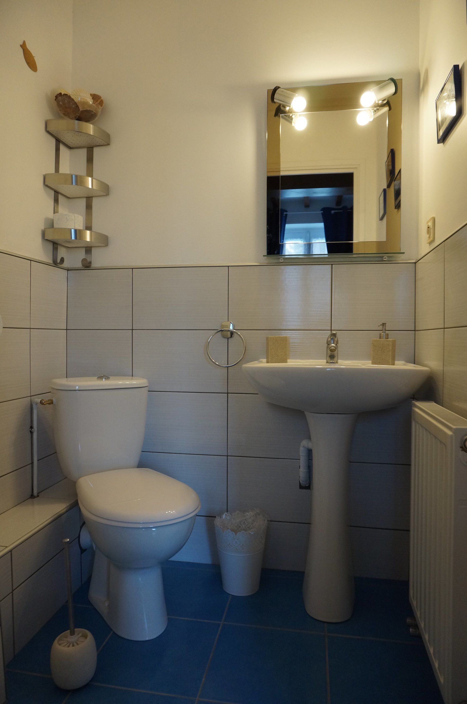 A bathroom with a toilet, sink, and mirror.