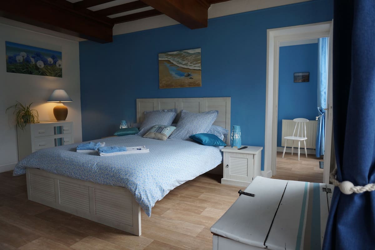 A bedroom with a bed, bedside tables, a lamp, and a chair.