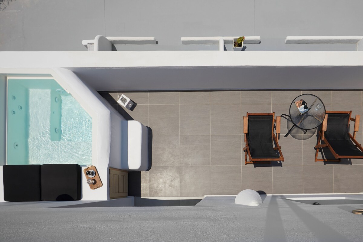 A modern outdoor pool area with a hot tub, lounge chairs, and a glass-enclosed jacuzzi.