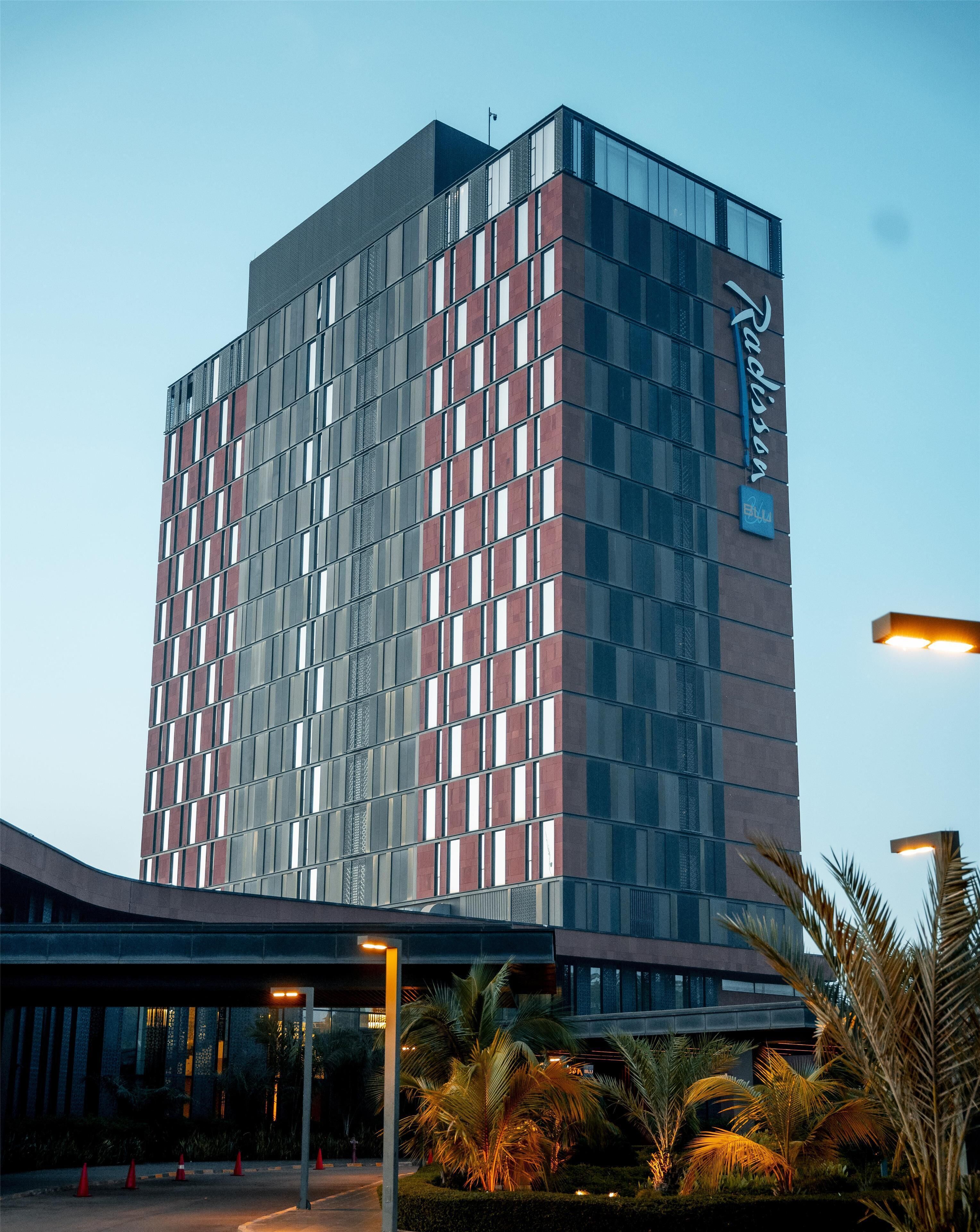 Ein modernes Hotelgebäude mit einem Gitter aus Fenstern und einer auffälligen Beschilderung an der Seite.