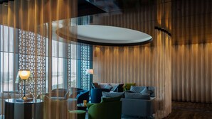 A modern living room with a round coffee table, a sofa, and a green armchair. - Radisson Blu Hotel & Conference Center, Niamey (Niamey)