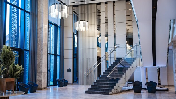 A modern lobby with a staircase, large windows, and contemporary lighting fixtures. - Radisson Blu Hotel & Conference Center, Niamey (Niamey)