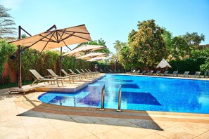 Alberca al aire libre, sombrillas en la alberca y camastros 