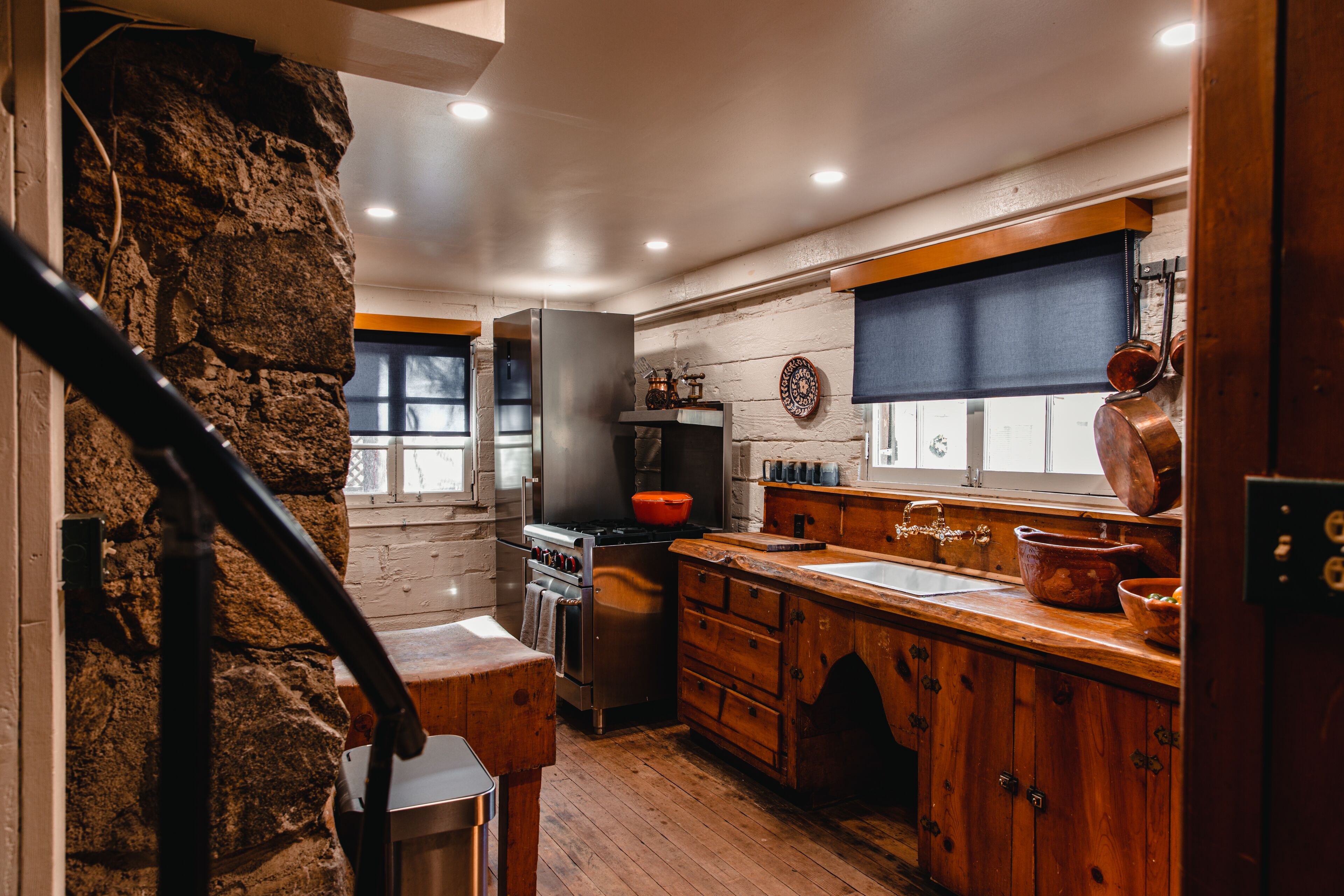 Une cuisine avec des meubles de rangement en bois, une cuisinière et un évier.